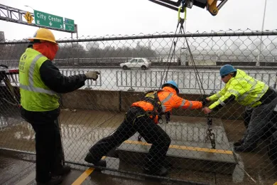 Contractor lowers scaffolding for work inside Morrison Bridge.