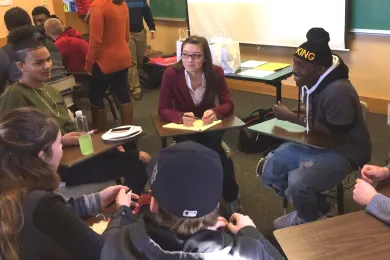 Four students sit in a circle talking