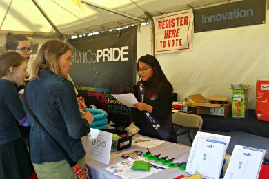 A Multnomah County employee chats with Pride Northwest festival attendees in 2016