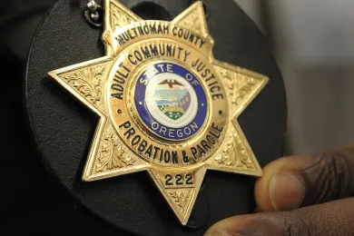 Parole and Probation Officer Jamiel Brown holds his badge