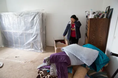Adelfa packs her family belongings after another apartment complex sale pushes rents up.