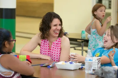 Chair Deborah Kafoury laughs with children enjoying a summer meal at Parkrose High.