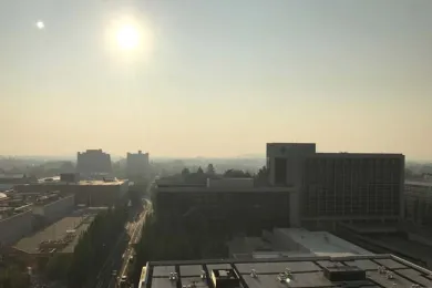 smokey sky over city and smoke coming from a house chimney