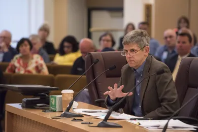 Tri-County Health Officer Dr. Paul Lewis speaks to commissioners before a vote on a new ambulance service contract