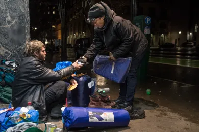 Perlia Bell, an outreach worker with JOIN, offers a tarp to Josh on a street in downtown Portland on Dec. 17, 2018.