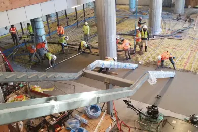 Pouring concrete for lobby floor over radiant heating system in Central Courthouse.