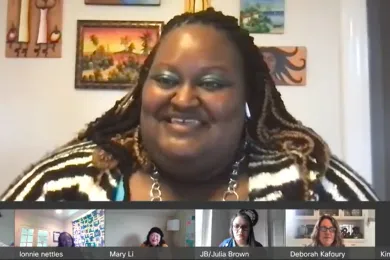 Kim Melton smiling while the Board listens