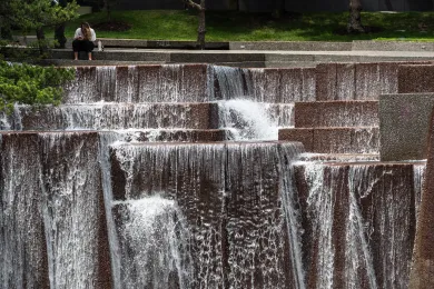 Person seeking relief near water in downtown Portland.