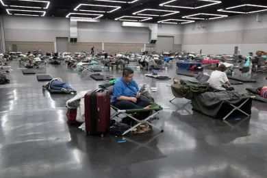 People spaced on cots inside the Oregon Convention Center