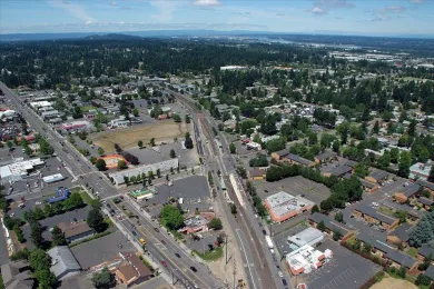 An aerial photo of an urban heat island in East County; most of the image is of wide asphalt streets and numerous parking lots, with more greenery far away