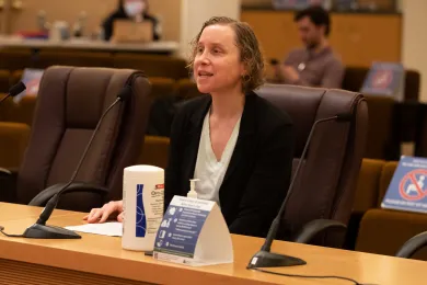 A photo of Mikki Gillette testifying in the Multnomah County board room