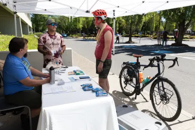 A volunteer picks up their heat mapping equipment from County staff
