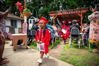 A preschooler dressed in cap and gown