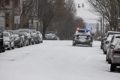 A photo of a police cruiser driving on the snow