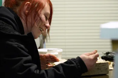 A woman looks down and smiles