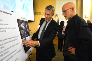 Architect Tom Vanderveer shares information about the preferred site with open house guest. 