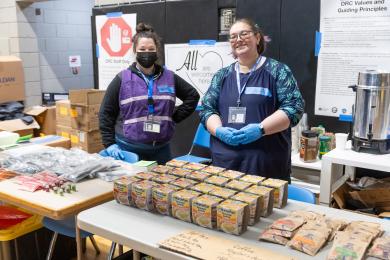 Two volunteers hand out supplies at a warming shelter