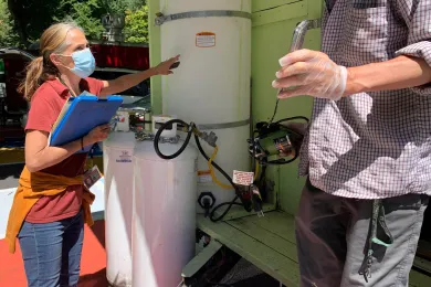 Inspecting a water tank at a food cart.