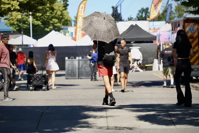 A person carries an umbrella for shade at an event Friday at the Expo Center.