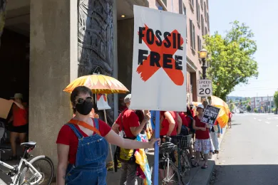 Woman holding sign that says Fossil Free