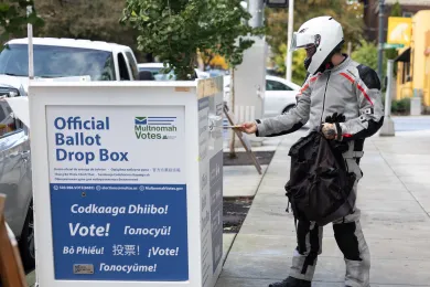 Voter drops their ballot at an official ballot drop box 