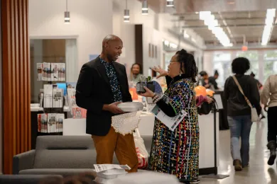 Dr. Deron Cole speaking with a woman 