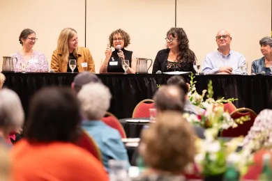 A panel discussion at the Hatfield School of Government's Public Service Recognition Event. Five panelists are seated on a stage behind a long table with a black tablecloth.