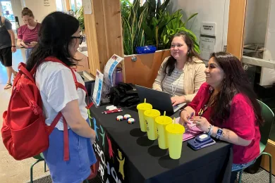 A community member talks with PFA Family Navigators from NAYA at a Preschool for All data walk event.