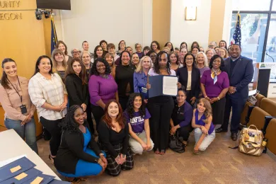 County leaders, staff and community partners stand together in the boardroom after the Board proclaimed October as Domestic Violence Awareness Month.