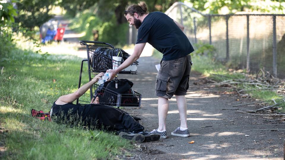 Outreach workers handing out water to unhoused people on June 28, 2021.