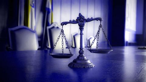 scales of justice on table in courtroom