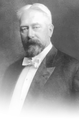 Black and white photo of a bearded man wearing white tie.