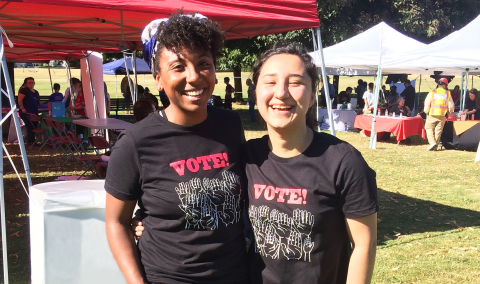 Two young girls laughing and smiling at an event