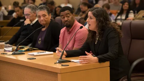 Chief Operating Officer Marissa Madrigal (right) address the board as Kory Murphy, member of the Safety, Trust and Belonging Advisory Council and equity and inclusion manager for the Department of County Assets looks on.