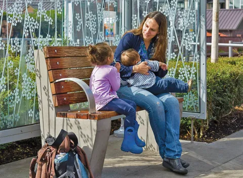 nursing mom with two children at a transit station
