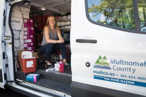 friendly health worker sitting inside a van