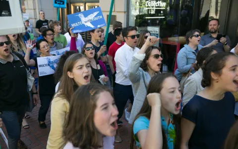 Chair Kafoury marching in a crowd with Commissioner stegman and others, people holding signs.