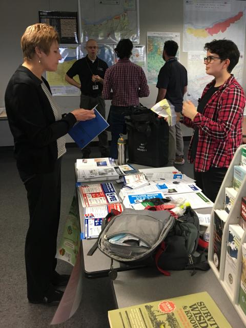 An intern staffs an informational table at an event.