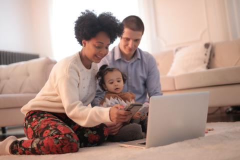 family with a baby on the floor having a video chat