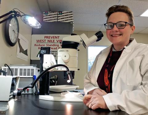 smiling vector control supervisor in a lab