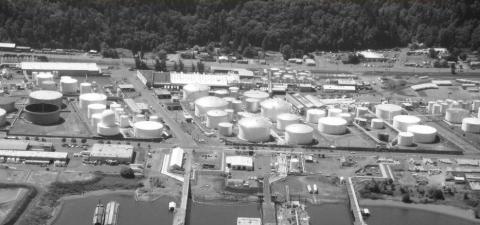 Large tanks for storing liquid fossil fuels adjacent to the Willamette River. 