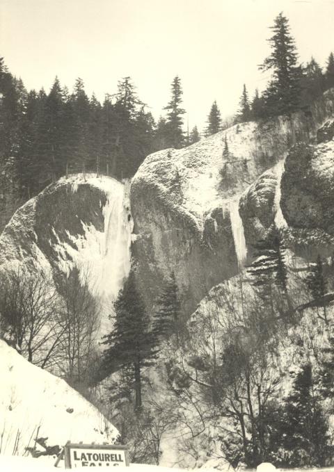 Photograph of two snowy cliffs with a waterfall cascading between them. It is unclear if the water is liquid or frozen.