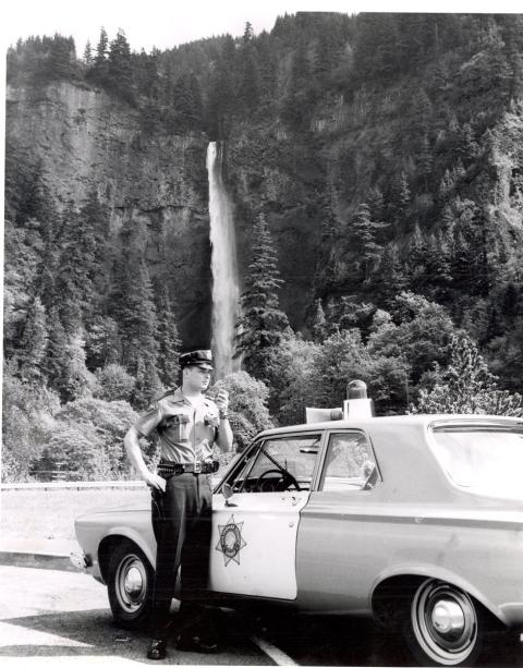 Sheriff's officer and patrol car parked near Multnomah Falls.