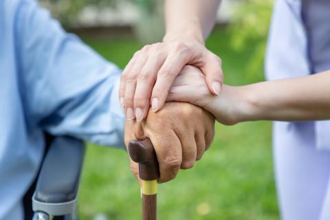 Three people's hands on top of one another in a show of teamwork