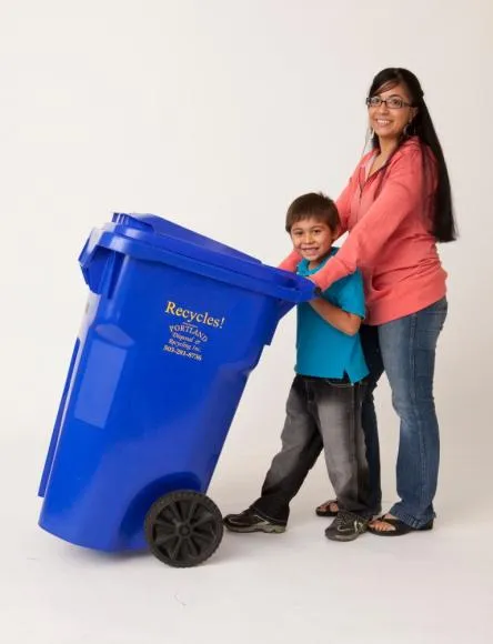 Woman and young child posing with a blue recycle bin.