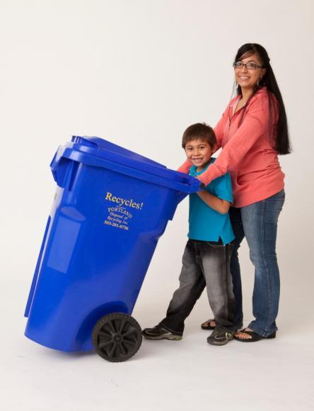 Woman and young child posing with a blue recycle bin.
