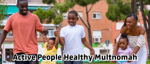 a Black couple and 3 children walking in a park