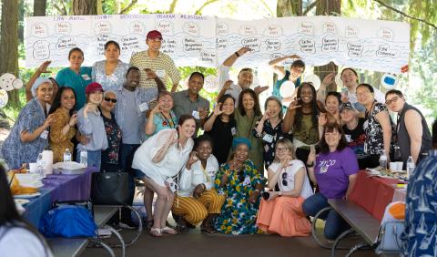 A group of community health workers pose at a park celebration.