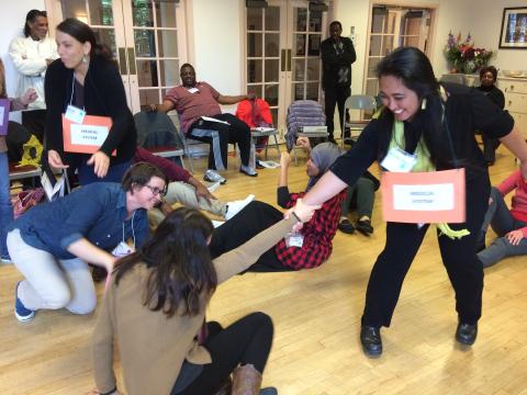 A participant playing the role of health systems lends a helping hand at a community health worker training exercise