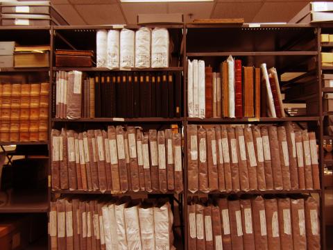 Several shelves in the Archives with rows of old volumes and ledgers